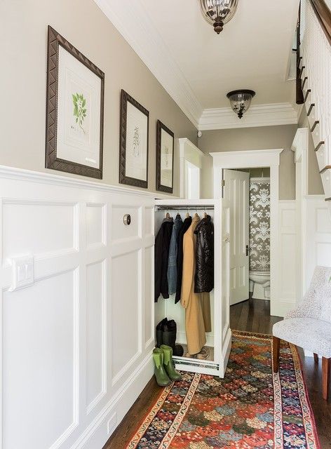 a hallway with white walls and carpeted flooring has pictures on the wall above it