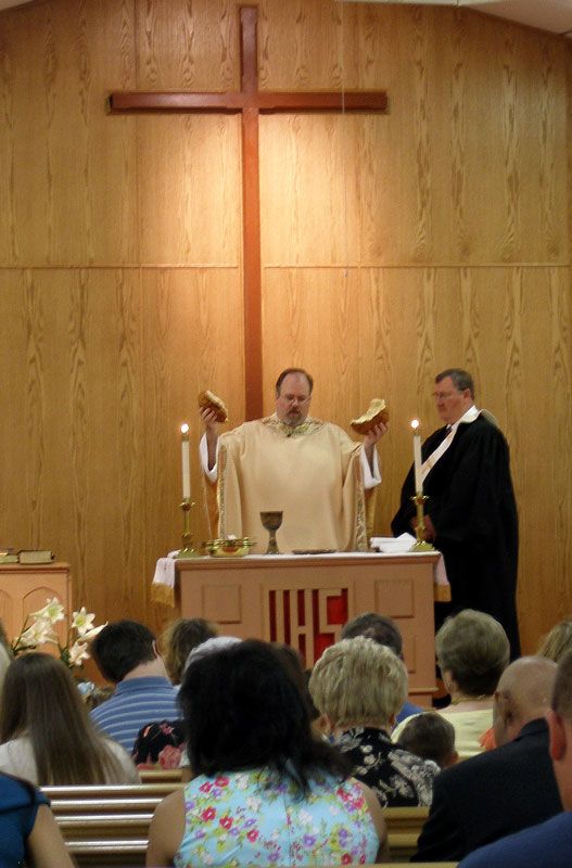 two priests standing at the alter in front of an audience