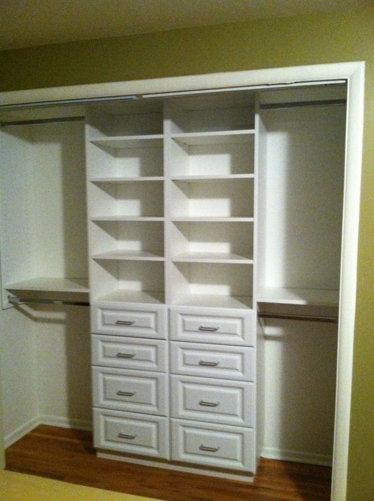 an empty closet with white drawers and shelves