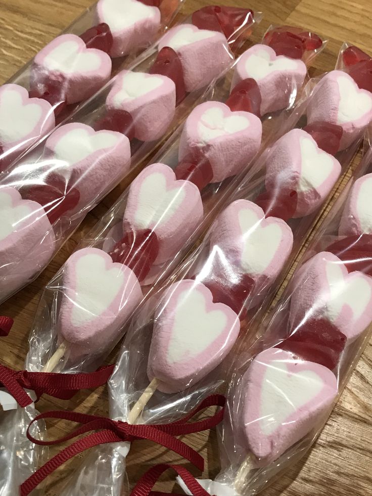 heart shaped lollipops wrapped in cellophane on a table