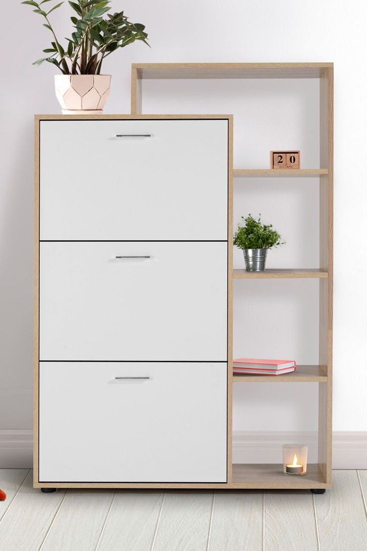 a white bookcase with three drawers next to a potted plant on top of it