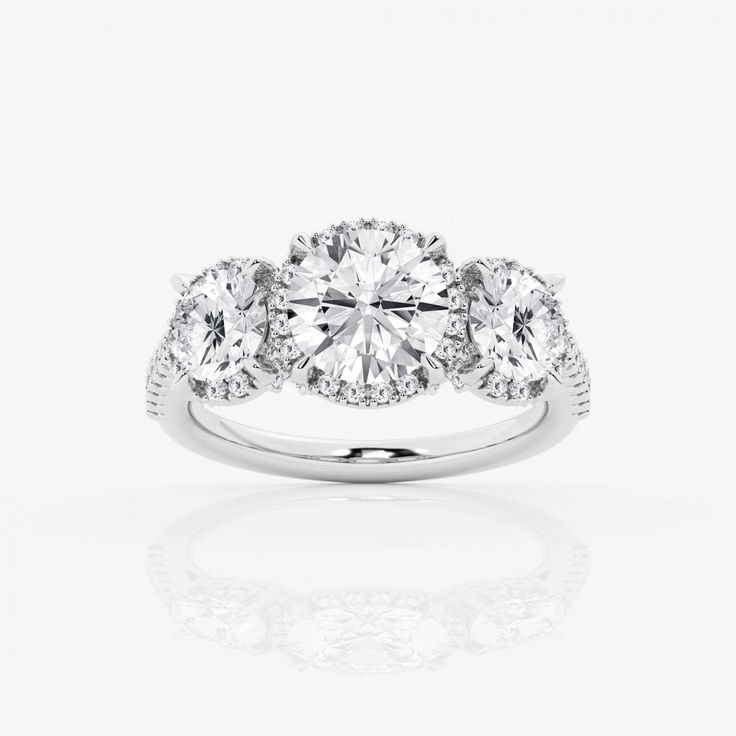 three stone engagement ring with diamonds on the sides and an oval center diamond in the middle