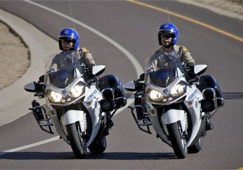 two men riding motorcycles down a curvy road