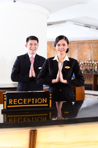 there are two people that are standing in front of a reception desk with their hands together