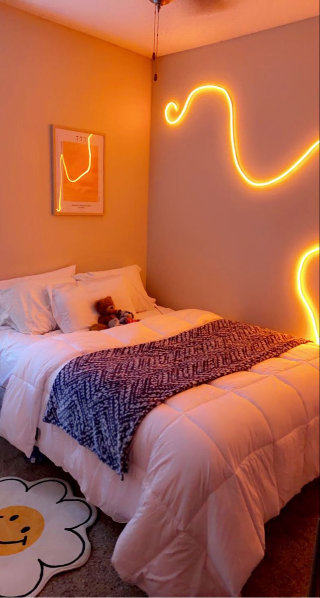 a bedroom with a bed, rug and neon lights on the wall above it that is shaped like an elephant