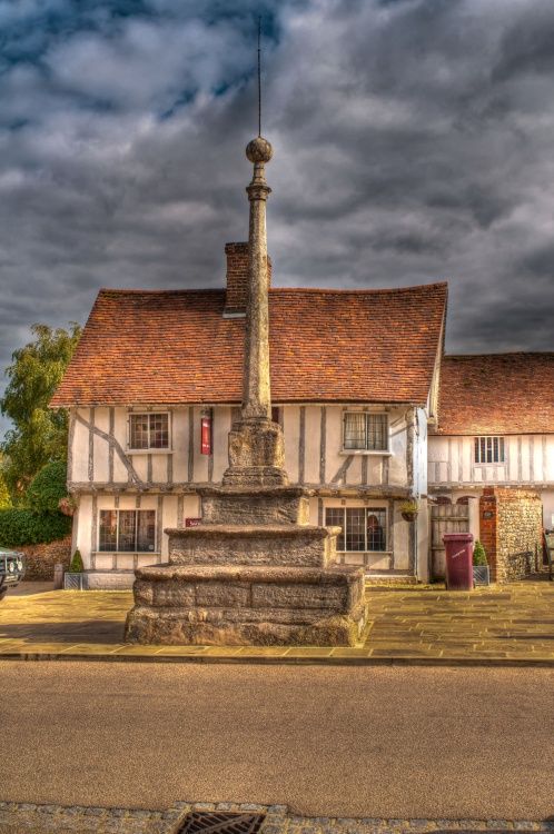 an old building with a fountain in front of it on the side of the road