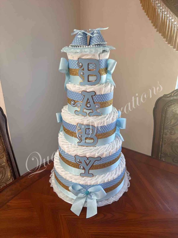 a blue and white diaper cake sitting on top of a wooden table