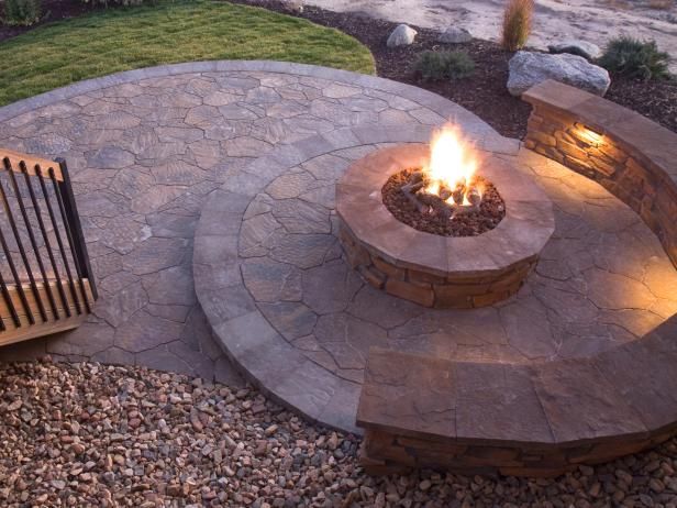 an outdoor fire pit surrounded by rocks and gravel