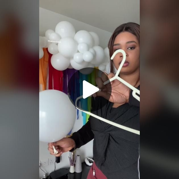 a woman is holding balloons in front of her face