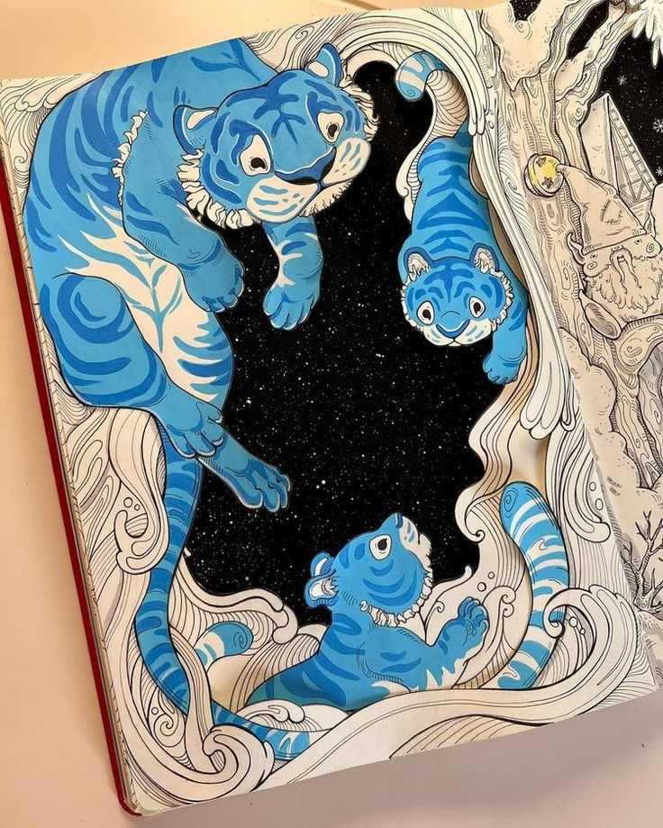 an open book with blue and white designs on it's cover, featuring two tigers