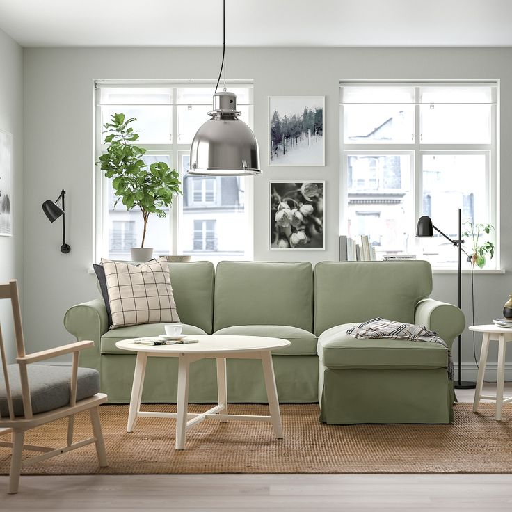 a living room filled with furniture next to two windows and a rug on the floor