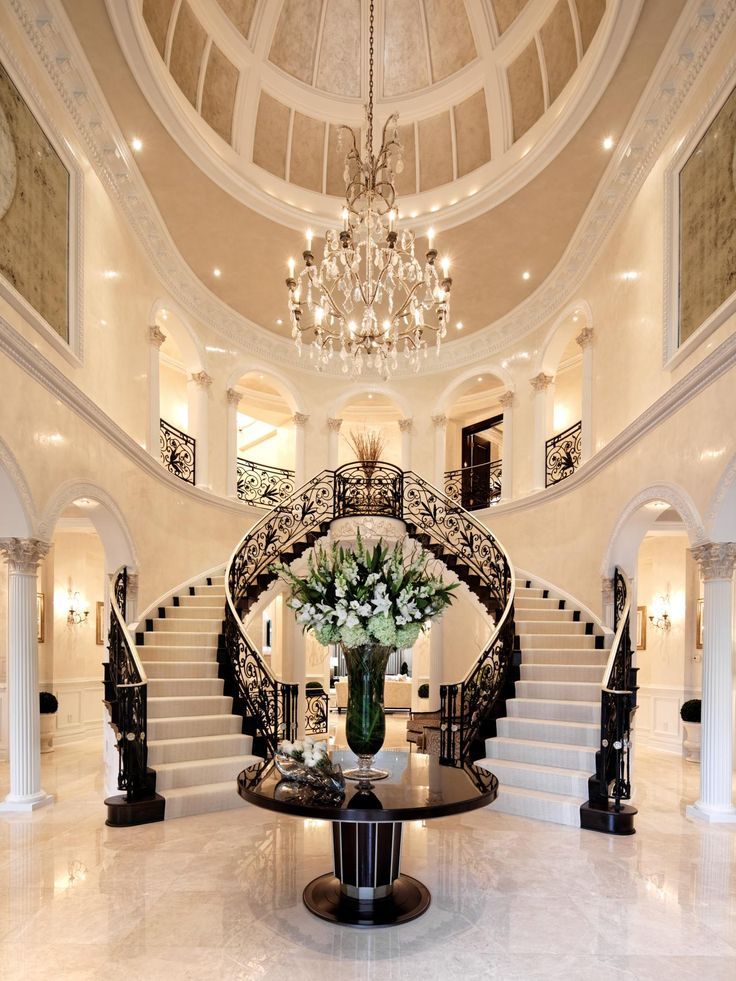 a large foyer with chandelier, marble flooring and stairs leading up to the second floor