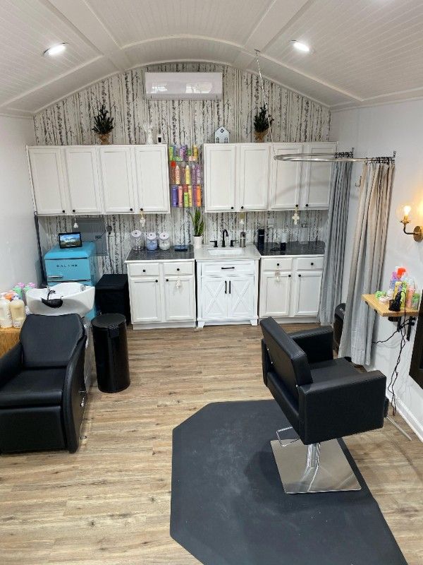 a room with two chairs and a rug on the floor in front of a kitchen