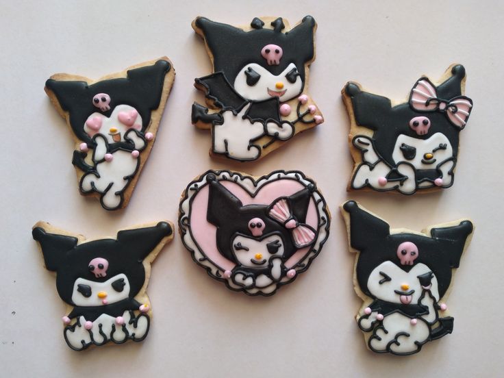 six decorated cookies with black and white cats in the shape of heart, cat's head, and hearts