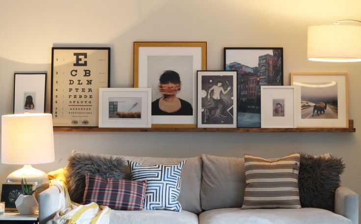 a living room filled with furniture and framed pictures on the wall above it's couch