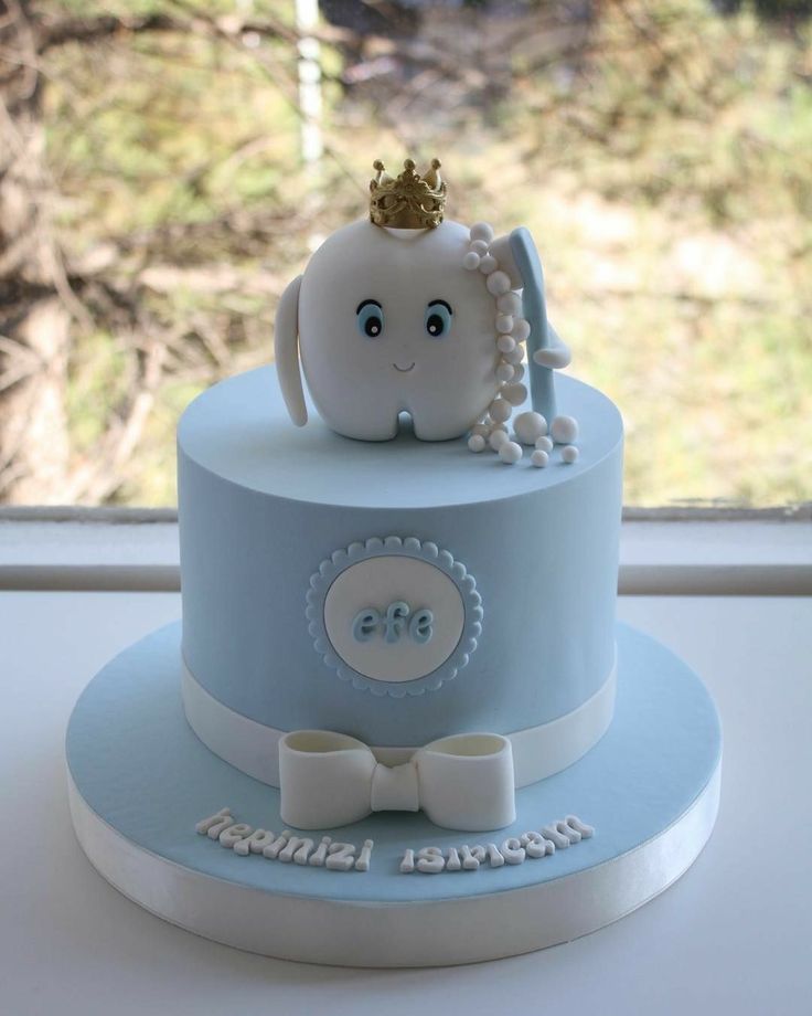 a blue and white cake with an elephant wearing a crown on it's head