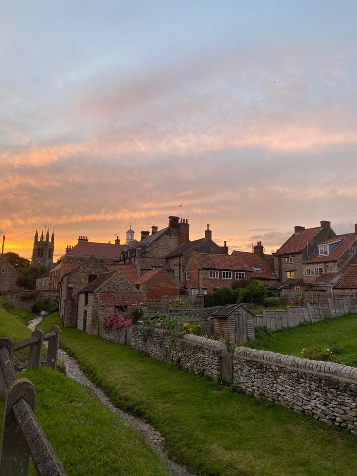 the sun is setting over an old village