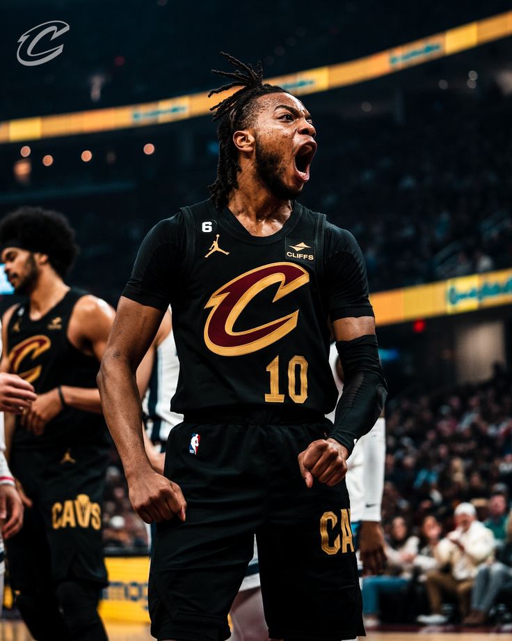 a basketball player is screaming while standing in front of other players on the court with his mouth open