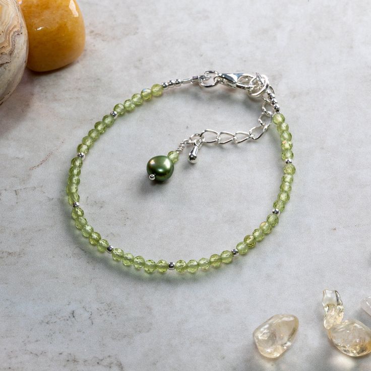 Peridot ~ Symbolises purpose and focus ~ Good Luck ~ Instils a sense of calm and safety ~ Detoxifying ~ believed to aid skin problems ~ reduces jealousy ~ encourages a positive outlook ~ Protection stone ~ Wards off negative energies This dainty Peridot and silver gemstone bracelet is handcrafted with care and attention to detail using:       3mm faceted peridot beads,       2mm sterling silver beads. The bracelet is hand threaded onto quality  19 strand durable but flexible beading wire making it very comfortable to wear. The bracelet measures 18cm + 3cm extender chain for an adjustable fit and fastens using a quality silver plated lobster claw clasp, the extender chain terminates with a delightful green Freshwater Pearl to compliment the Peridot. Peridot is one of the birthstones for the Nickel-free Green Beaded Bracelets, Silver Jade Beaded Bracelets As Gift, Adjustable Lime Green Bracelets As Gift, Nickel-free Green Beaded Bracelets As A Gift, Nickel-free Green Beaded Bracelets For Gift, Nickel-free Green Beaded Bracelet For Gift, Green Nickel-free Beaded Bracelets As A Gift, Lime Green Birthstone Jewelry For Gifts, Lime Green Birthstone Jewelry Gift