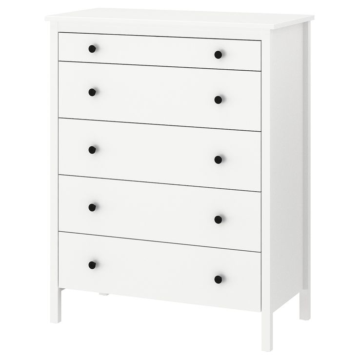 a white chest of drawers with black knobs