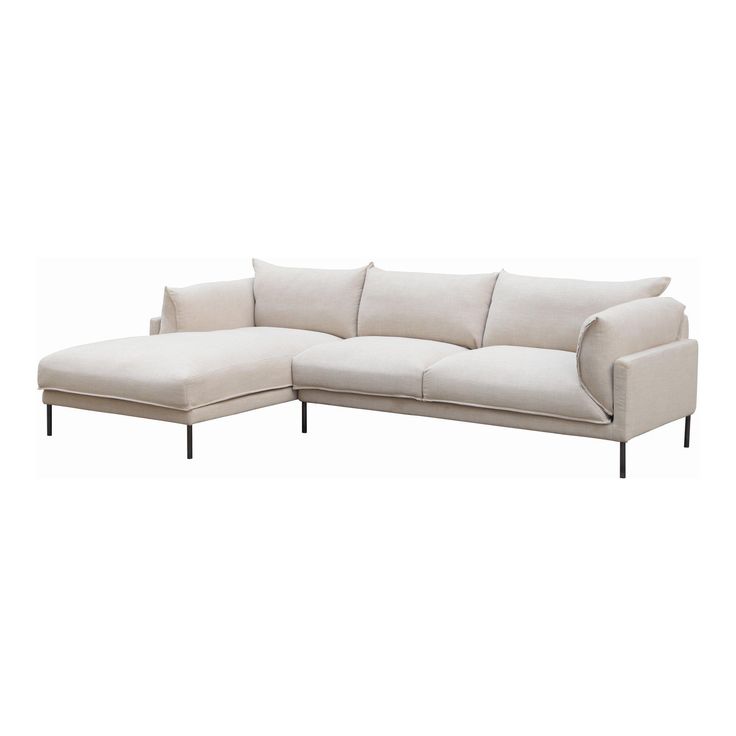 a white sectional couch sitting on top of a wooden floor next to a white wall