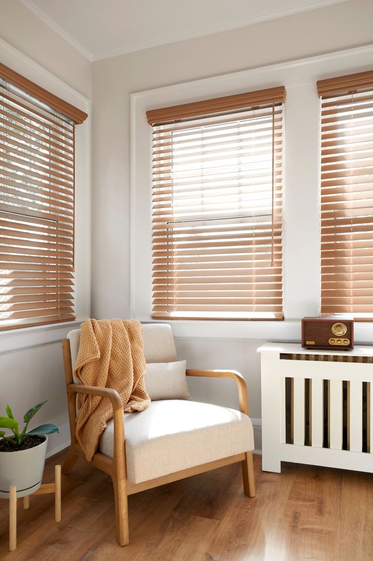 a living room with wooden blinds and white furniture