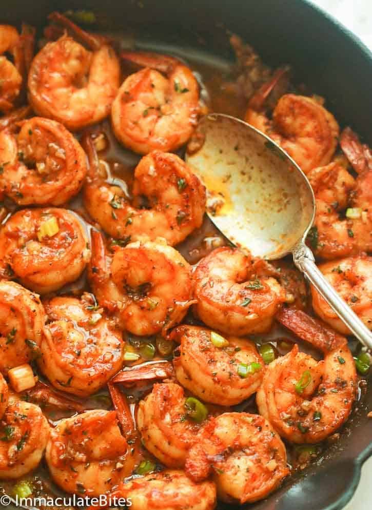 a skillet filled with cooked shrimp and sauce