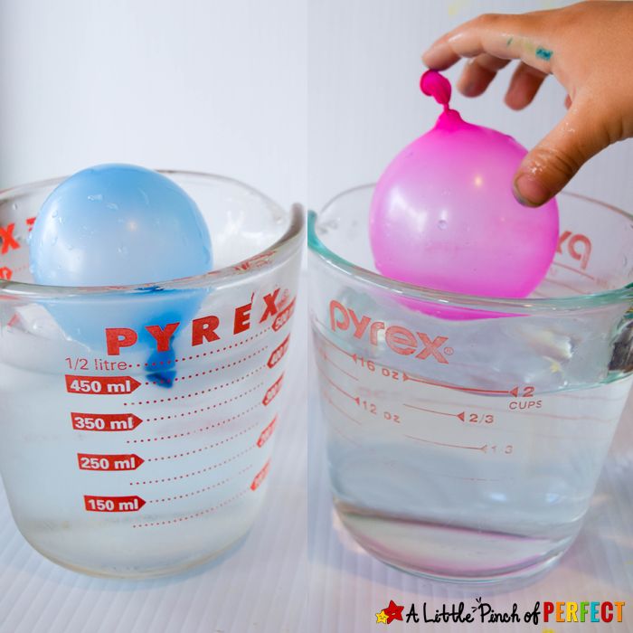 a hand is holding a ball in a measuring cup and another hand is placing it into the bowl