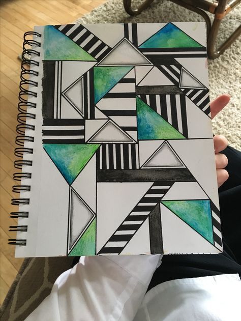 someone holding up a notebook with an artistic design on it