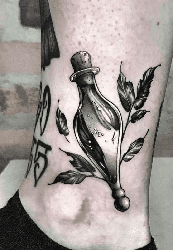 a black and white photo of a bottle with leaves on the bottom of its leg