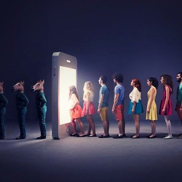 a group of people standing in front of an open cell phone with the screen lit up