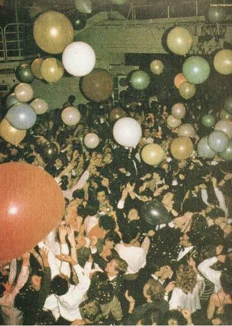 a large group of people with balloons in the air