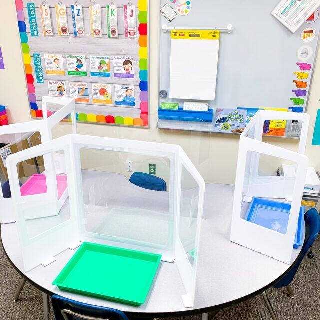 an empty classroom with desks made out of cardboard boxes and colored papers on the walls