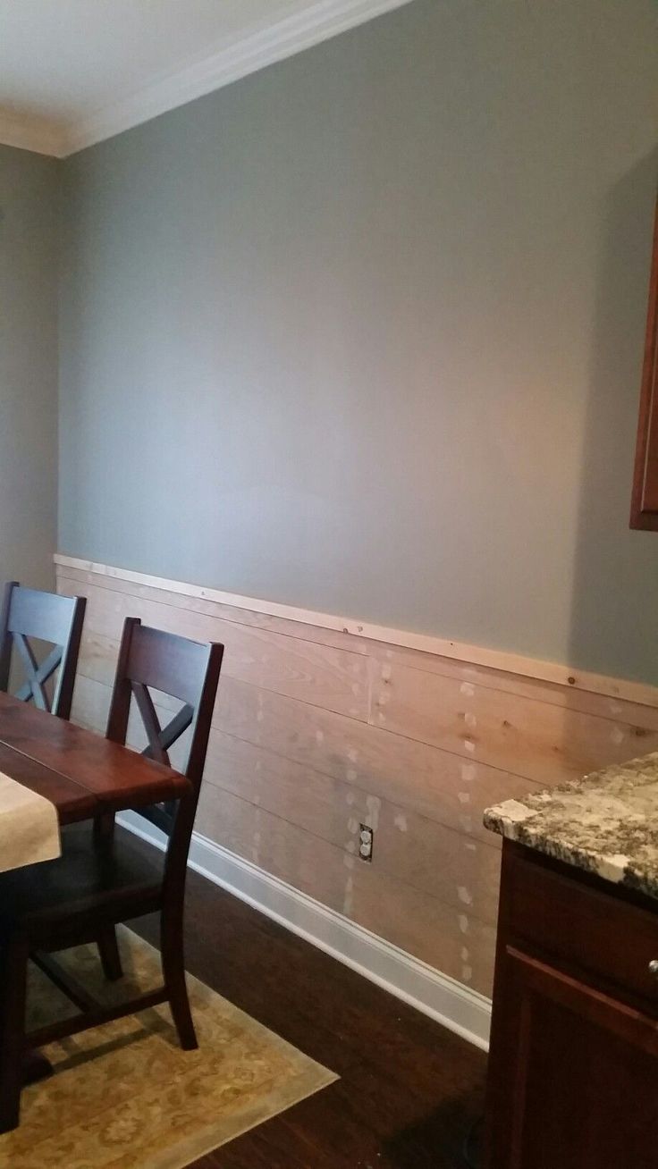 a dining room table and chairs in front of a wall