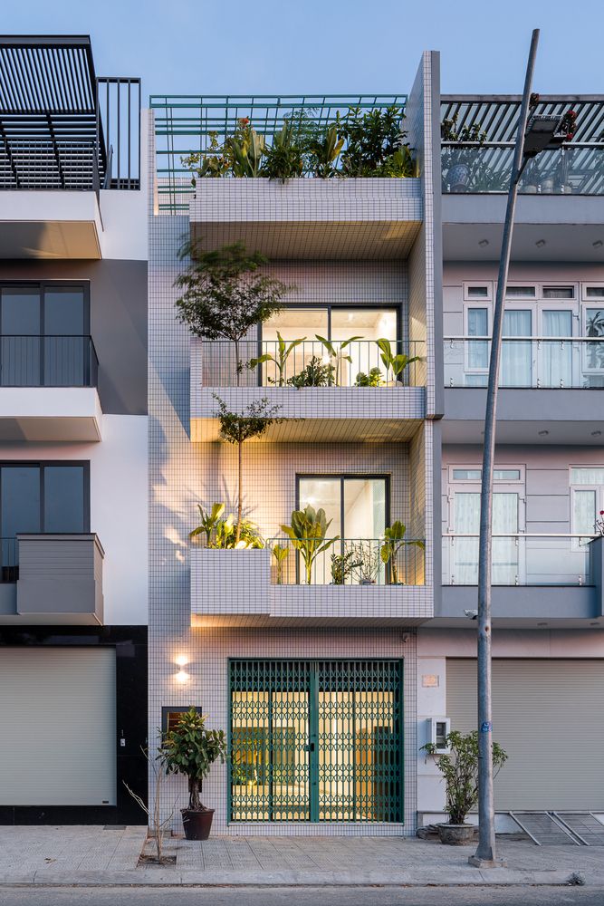 an apartment building with plants growing on the balconies