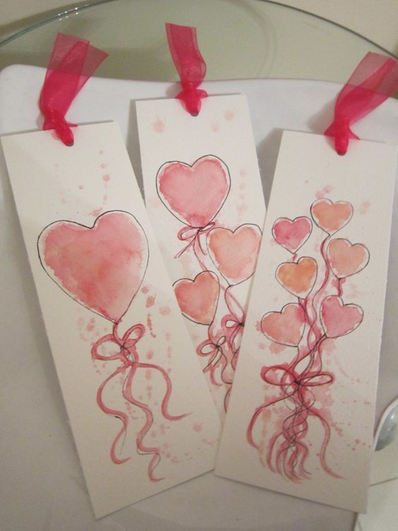 three valentine's day cards with watercolors and red ribbon hanging from hooks