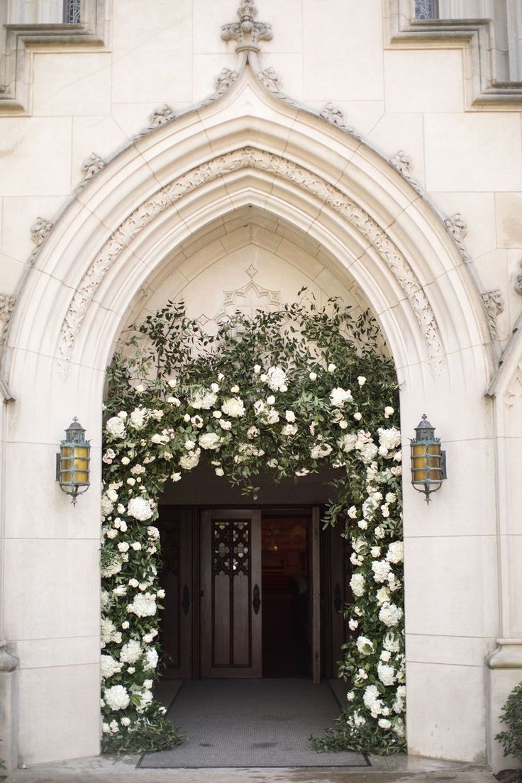 an entrance to a building with white flowers on it