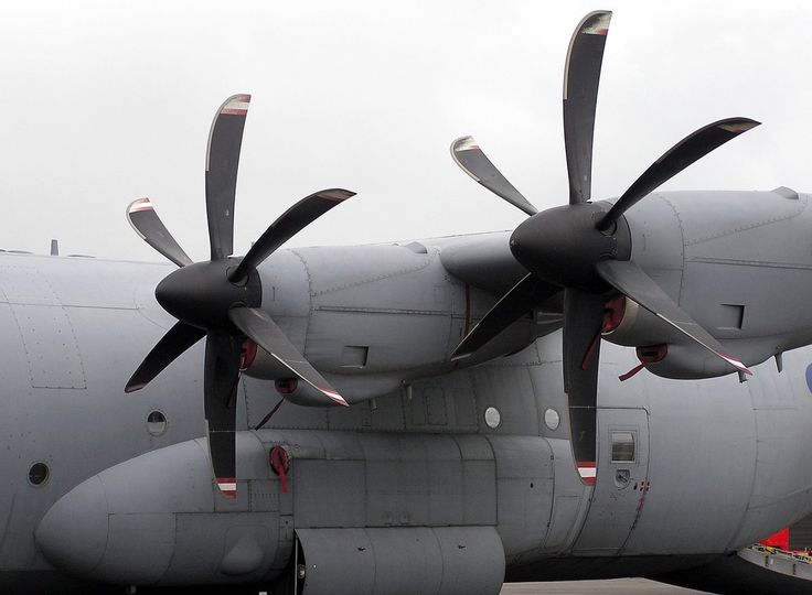 two large propeller airplanes parked next to each other