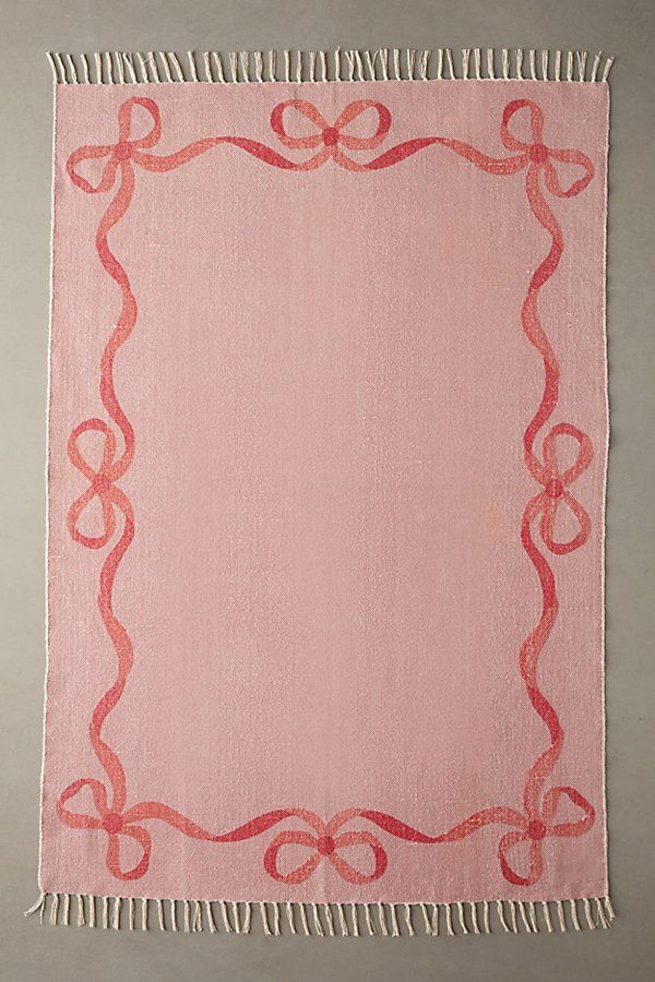 a pink and red rug with an ornate frame on it's side, hanging from the wall