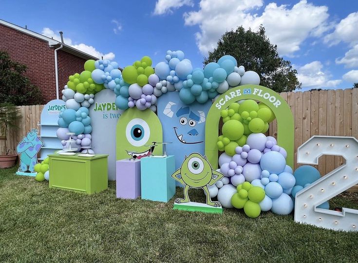 a birthday party with balloons and decorations in the shape of numbers, monsters and fish