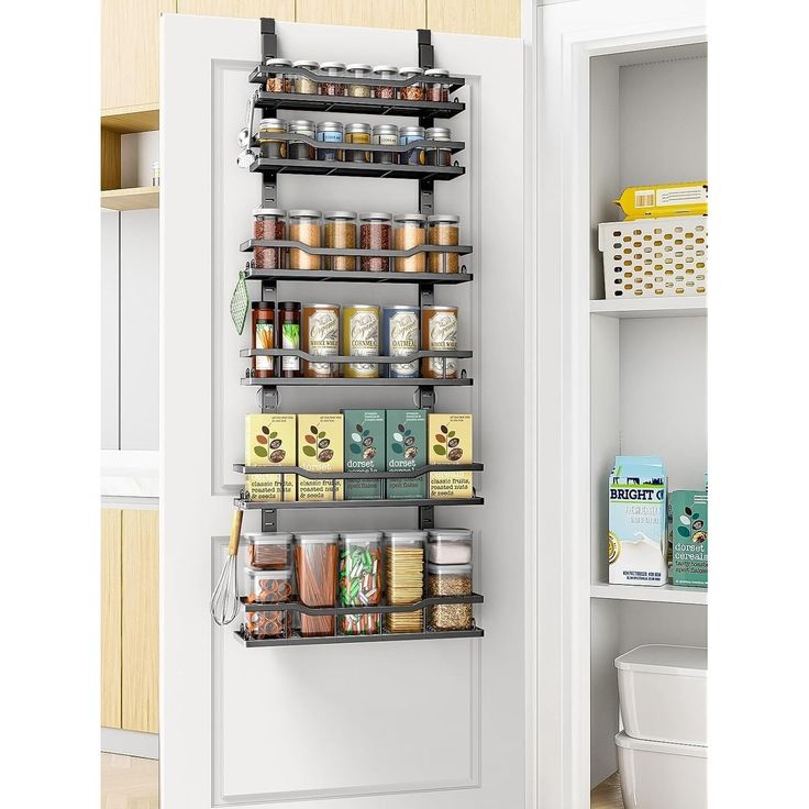 the pantry door is open to show spices and other items on shelves in front of it