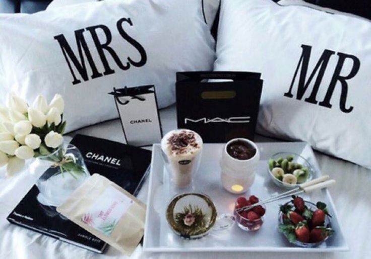 a tray with some food and drinks on top of it next to two pillows that say mr and mrs