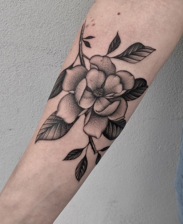 a black and white flower tattoo on the arm