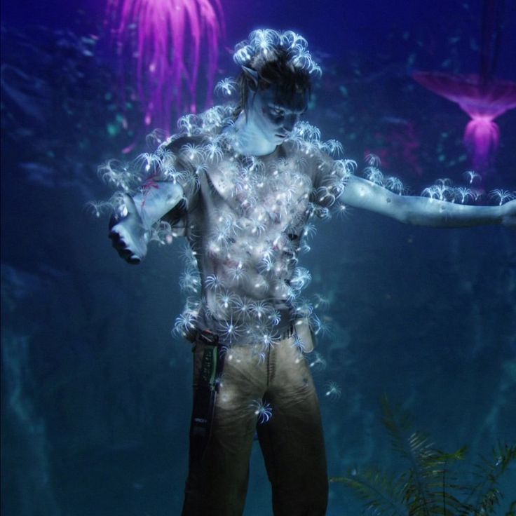 a man with his arms outstretched in front of an aquarium