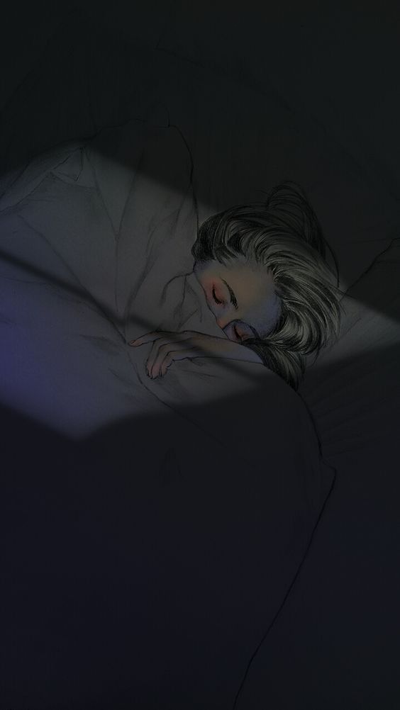 a woman laying in bed with her head on the pillow and light shining through it