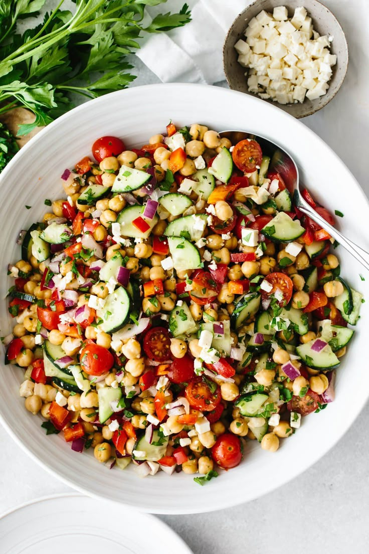 a white bowl filled with salad next to rice and parsley on the side,