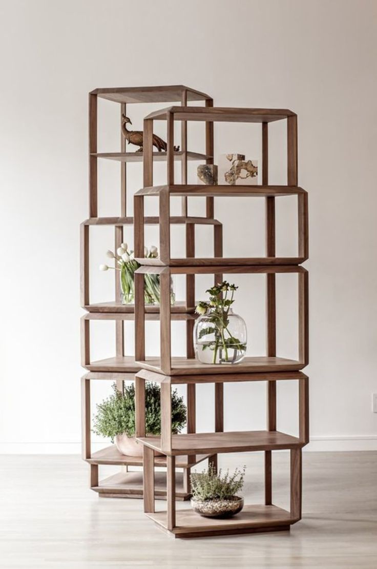 a wooden shelf filled with plants on top of a hard wood floor