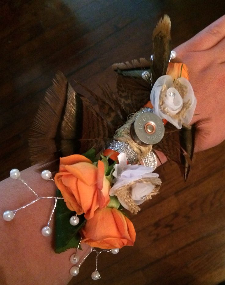 a woman's arm is decorated with flowers and pearls, beads and feathers on it