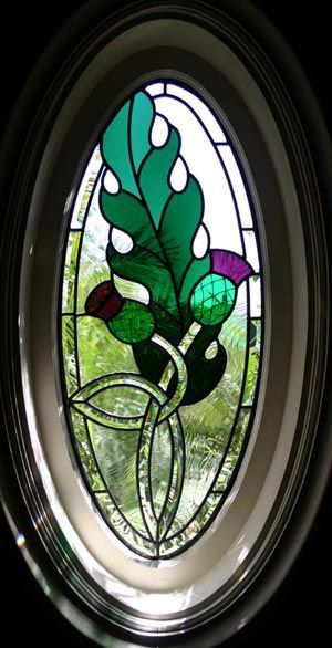 a stained glass window with a green leaf on it