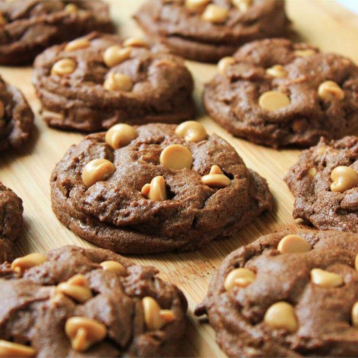 chocolate cookies with nuts are arranged on a cutting board